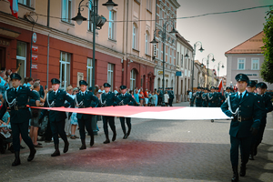 Na zdjęciu policjanci niosą flagę Polski