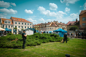 Na zdjęciu policjant stoi przy stoiskach informacyjnych