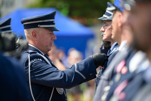 Na zdjęciu Zastępca Komendanta Głównego przypina medal policjantowi