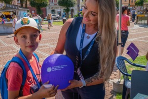 Na zdjęciu kobieta z dzieckiem trzymającym balon z obchodów święta policji