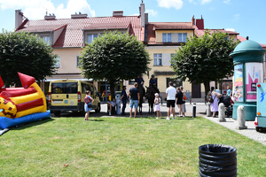 Na zdjęciu dzieci i dorośli stoją przy policjantach na koniach