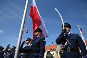 Na zdjęciu policjanci kompanii honorowej wieszają flagę