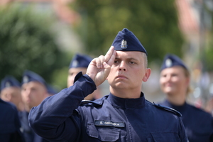 Na zdjęciu policjant oddaje honor