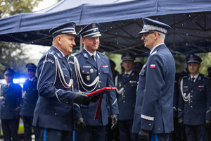 Policjanci wręczają generałowi upominek