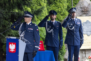 Generał podczas przemówienia, w tle dwóch policjantów