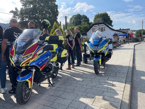 Zbliżenie na motocykle i stojących obok uczestników warsztatów