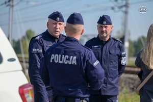 Na zdjęciu widoczni trzej umundurowani policjanci rozmawiający ze sobą