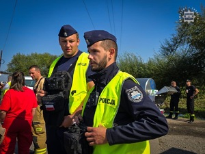 Na zdjęciu dwaj umundurowani policjanci w kamizelkach odblaskowych