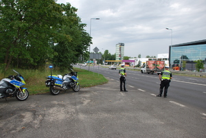 Policyjni motocykliści stojący przy drodze