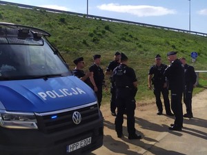 zdjęcie przedstawia komendanta z policjantami stojącymi przy radiowozie