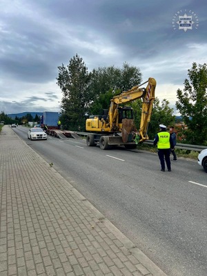 Na zdjęciu policjanci pilotujący koparkę