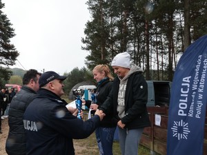 Na zdjęciu uczestniczki biegu na podium podczas wręczania im statuetek pamiątkowych przez Naczelnika Wydziału Doboru i Szkolenia KWP w Katowicach.