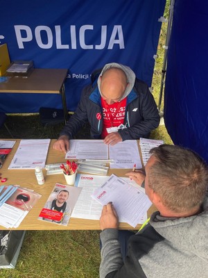 Na zdjęciu przedstawiciele Wydziału Doboru i Szkolenia KWP w Katowicach na stanowisku DKMS oraz uczestnik biegu który zdecydował się na pobranie wymazu w celu rejestracji jako dawca szpiku.