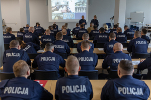 Zdjęcie przedstawia umundurowanych uczestników kursu aspiranckiego, zwróconych tyłem do fotografującego.