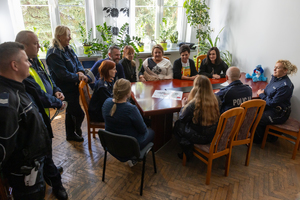 Na zdjęciu policjanci i nauczyciele rozmawiają razem przy stole.