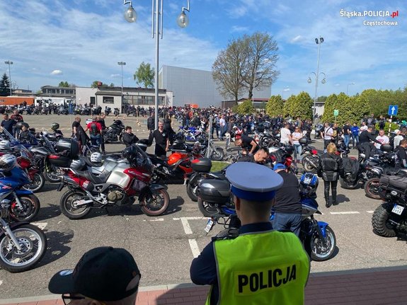 Policjantka na tle zaparkowanych motocykli i ich użytkowników