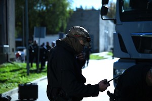 Zdjęcie przedstawia policjanta trzymającego w ręku stacje