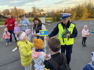 Na zdjęciu widoczna policjantka rozdająca odblaski