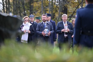 Na zdjęciu uczestnicy uroczystości trzymający znicze.