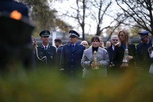 Na zdjęciu uczestnicy uroczystości trzymający znicze.