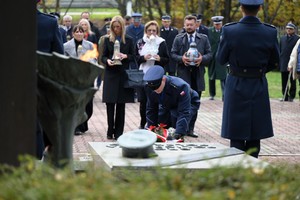 Na zdjęciu policjant składający kwiaty na grobie.