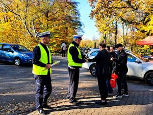 Na zdjęciu policjanci ruchu drogowego rozdający odblaski.