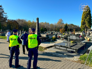 Na zdjęciu dwóch policjantów patrolujących cmentarz.