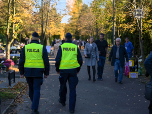 Na zdjęciu dwójka policjantów patrolujących cmentarz.