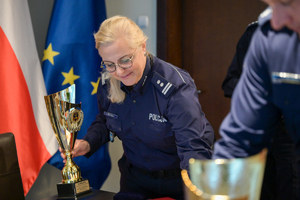 Na zdjęciu policjantka oraz puchary.