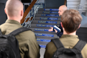 Na zdjęciu uczniowie z klasy mundurowej rozmawiają z policjantem.