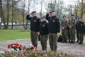 Na zdjęciu uczniowie technikum mundurowego stojący przy pomniku. Uczniowie oddają honor.