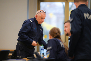 Na zdjęciu oficer Policji rozmawiający z innymi policjantami podczas rozpoczęcia kursu aspiranckiego w katowickiej komendzie wojewódzkiej.