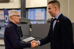 na zdjęciu wojewódzki komendant przekazujący pamiątkowy upominek mężczyźnie.