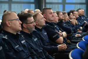 na zdjęciu szereg policjantów siedzących na krzesłach.