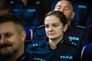 na zdjęciu twarz policjantki pośród innch twarzy policjantów.