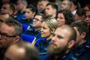 na zdjęciu siedzący policjanci i policjantki.