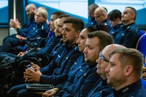 na zdjęciu umundurowani policjanci siedzący na krzesłach.