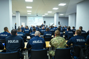 Zdjęcie przedstawia: grupę policjantów siedzących w ławkach.