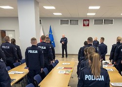 Na zdjęciu uczestnicy szkolenia zawodowego podoficerskiego stoją na baczność. Przed nimi na środku sali stoi Zastępca Komendanta Wojewódzkiego Policji w Katowicach inspektor Jacek Stelmach oraz Naczelnik Wydziału Doboru i Szkolenia KWP w Katowicach młodszy inspektor Krzysztof Kazek, którzy witają uczestników.