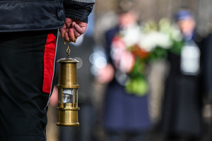 Na zdjęciu zbliżenie na stylizowaną lampkę górniczą trzymana przez ratownika górniczego