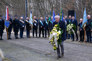 Na zdjęciu mężczyzna składający wieniec pod Pomnikiem upamiętniającym zmarłych w katastrofie MTK