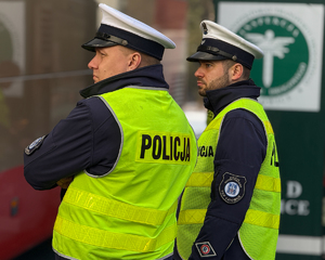 Na zdjęciu widać policjantów stojących w kamizelce ruchu drogowego