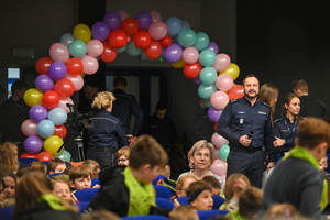 zdjęcie przedstawia policjantów dzieci a w tle balony