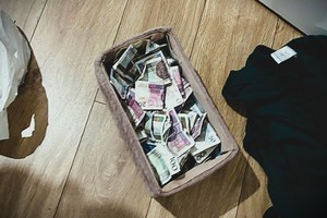na zdjęciu pudełku na ziemi, w której umieszczone są banknoty