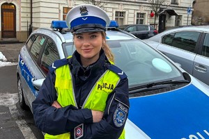 Zdjęcie policjantki w mundurze przy radiowozie