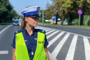 Zdjęcie policjantki w mundurze i kamizelce odblaskowej na drodze