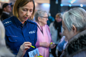 Zdjęcie policjantki w mundurze przekazującej seniorce odblask