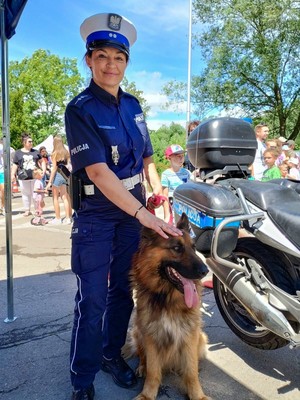 Zdjęcie policjantki w mundurze z psem służbowym