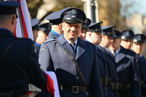 zbliżenie na policjanta z kompanii honorowej w tle inni policjanci