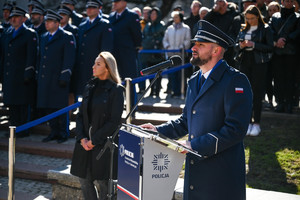 zdjęcie kolorowe lektor uroczystości w tle zaproszeni goście